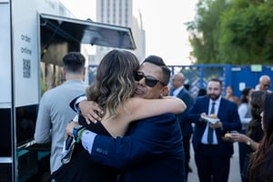 CCA CEO Nella McOsker and State Assemblymember Mark Gonzalez embrace at the Central City Association’s Elected Officials and Chiefs of Staff Reception at LA Plaza de Cultura y Artes in Downtown Los Angeles, engaging in conversation in a lively outdoor setting.