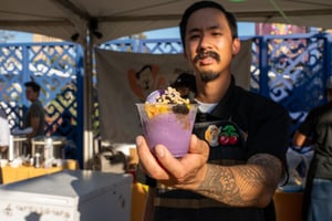 A vendor serves food to guests at the Central City Association’s Elected Officials and Chiefs of Staff Reception at LA Plaza de Cultura y Artes in Downtown Los Angeles, contributing to the lively outdoor event atmosphere.