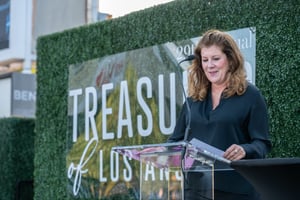 CCA Chair of the Board makes formal remarks from a podium at the Treasure of Los Angeles event.